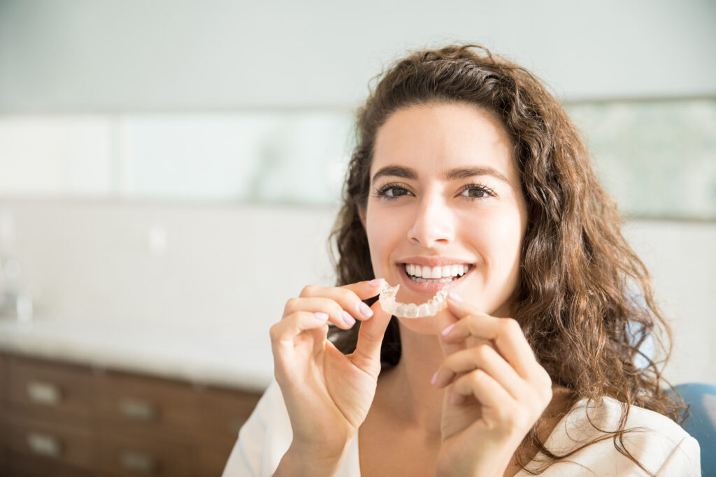 Shop - portrait beautiful patient holding orthodontic retainers dental clinic - Greek List
